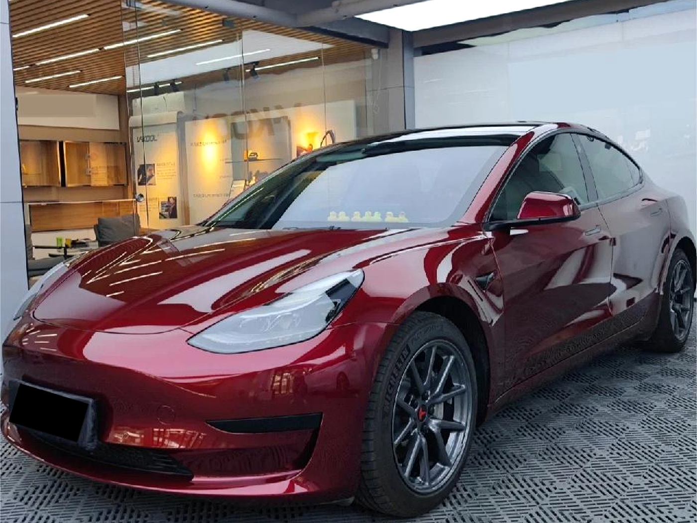 ArmorHue glossy metallic red vehicle wrap in a premium detail bay